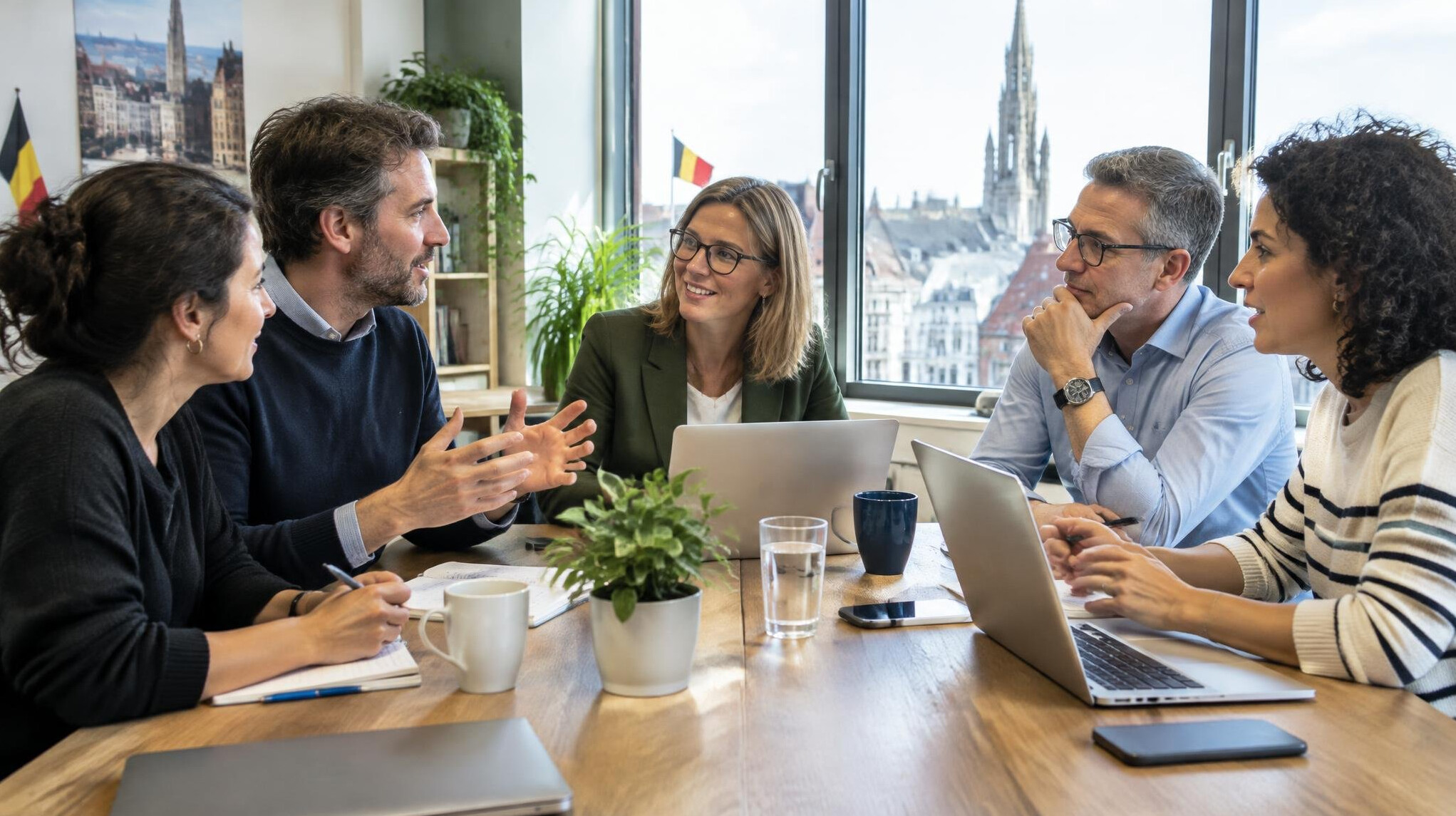 Diverse team of colleagues discussing around a table in a bright office